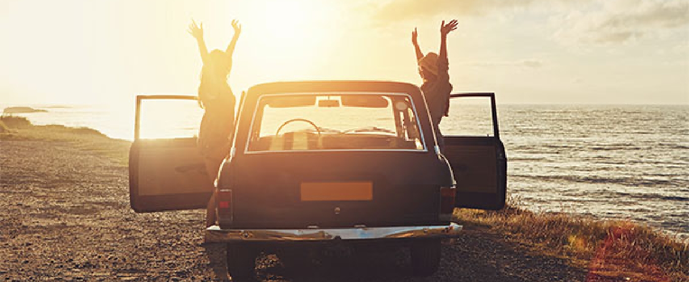 personas con un coche en la playa